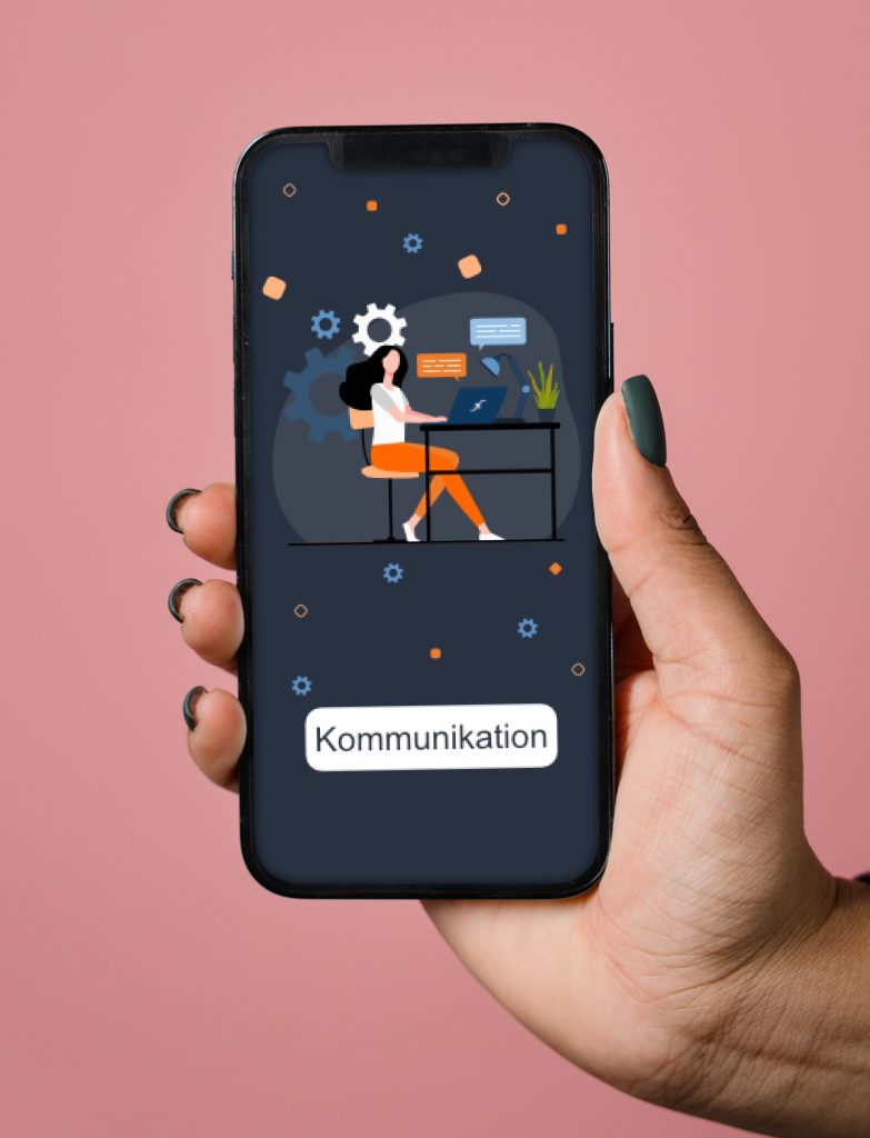 Hand hält ein Smartphone, auf dem eine Grafik einer Frau zu sehen ist, die an einem Schreibtisch arbeitet. Der Bildschirm zeigt Elemente der Kommunikation und Technologie, einschließlich Sprechblasen und Zahnrädern.