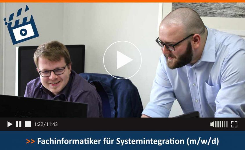 Zwei Fachinformatiker arbeiten gemeinsam an Computerbildschirmen, während sie ein Projekt zur Systemintegration besprechen. Im Hintergrund ist ein moderner Büroraum zu sehen.