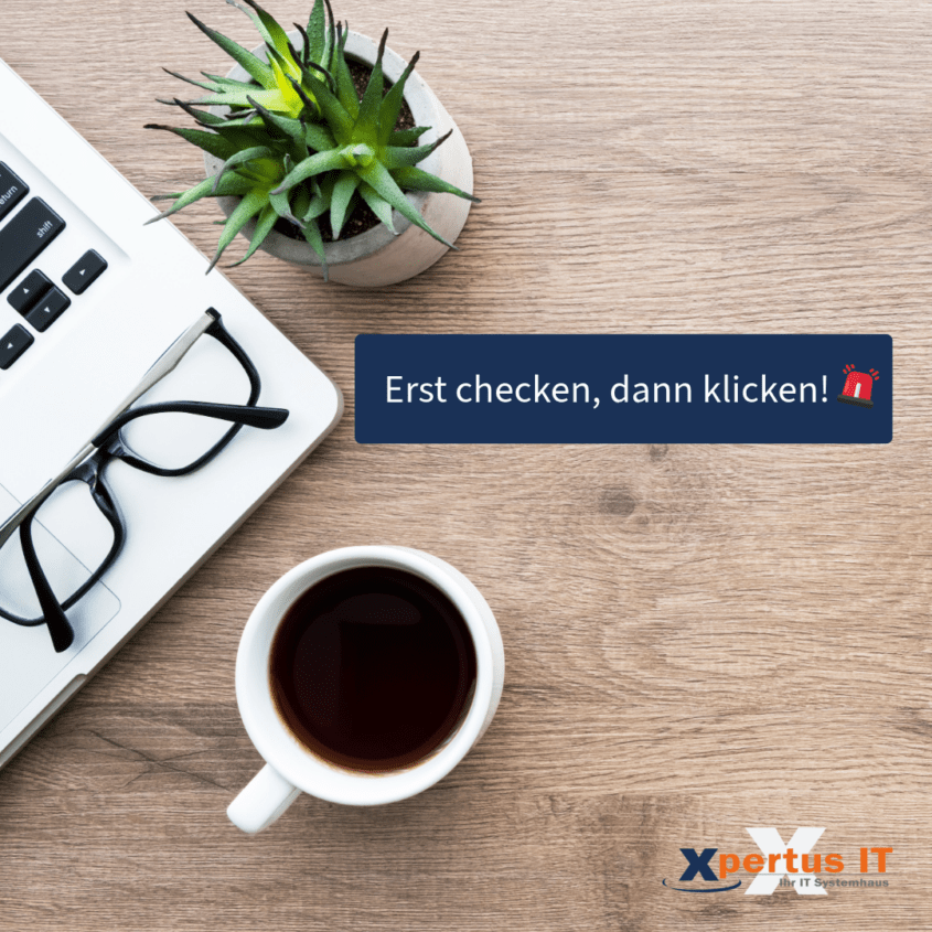 Laptop mit Tastatur, Brille und Kaffeetasse auf einem Holzschreibtisch, mit der Aufforderung "Erst checken, dann klicken!" von Xpertus IT.